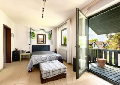 helles Schlafzimmer mit Zugang zum Balkon mit Blick in den Garten des Hauses in ruhiger Lage von Düsseldorf