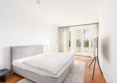 Helles, freundliches Schlafzimmer mit großen Fensterflächen