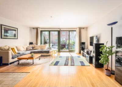 heller Wohnraum mit großer Fensterfront und Zugang zum Balkon